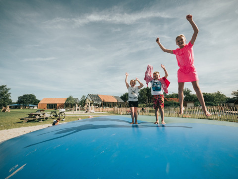 Kinderen springen en spelen op een luchtkussen bij vakantiepark De Klepperstee in Zuid-Holland, Nederland.