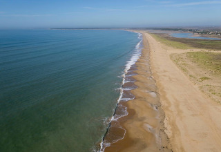 Strand bij Flower Camping Le Pré des Sables, Pays de la Loire, Frankrijk, met rustig water en zand.
