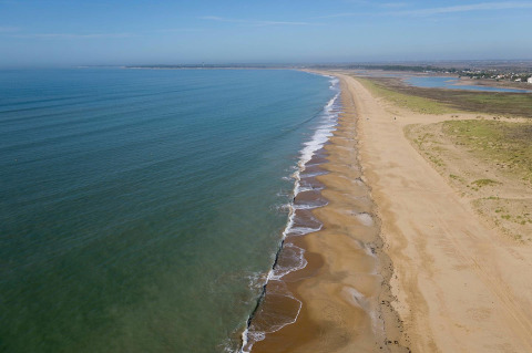 Beach near Flower Camping Le Pré des Sables, Pays de la Loire, France, showing calm sea and sandy shore.