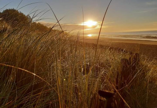 Sunset over sandy beach and dunes at Flower Camping Le Pré des Sables, Pays de la Loire, France.