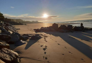 Escena de playa al atardecer en Flower Camping Le Pré des Sables, Pays de la Loire, Francia.