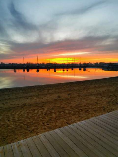 Precioso atardecer sobre la playa tranquila en Flower Camping Le Pré des Sables, Pays de la Loire, Francia.
