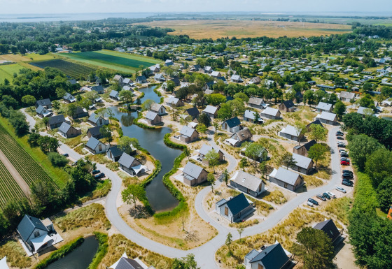 Luchtfoto van vakantiepark De Klepperstee met huisjes, waterpartijen en groene velden in Zuid-Holland.