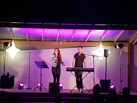 Espectáculo nocturno en Flower Camping Le Pré des Sables con cantante y tecladista en Pays de la Loire, Francia.