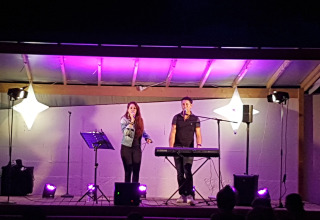 Espectáculo nocturno en Flower Camping Le Pré des Sables con cantante y tecladista en Pays de la Loire, Francia.