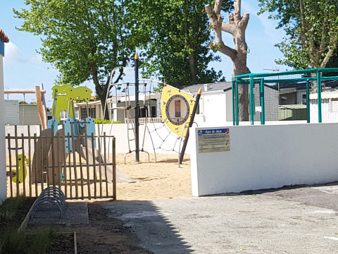 Parco giochi con struttura per arrampicata e scivolo al Flower Camping Le Pré des Sables, Pays de la Loire, Francia.