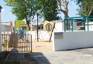 Parco giochi con struttura per arrampicata e scivolo al Flower Camping Le Pré des Sables, Pays de la Loire, Francia.