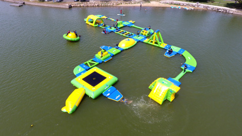 Inflatable obstacle course floating on a lake at Flower Camping Le Pré des Sables in Pays de la Loire, France.
