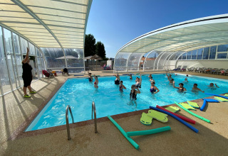 Wassergymnastik mit Teilnehmern und Trainerin im überdachten Pool bei Flower Camping Le Pré des Sables.