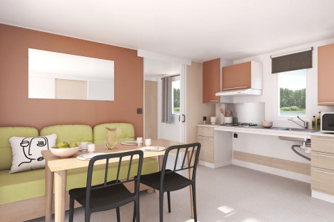 Bright, modern open-plan kitchen and dining area with sofa at Flower Camping Le Pré des Sables holiday park.