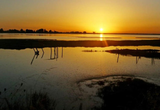 Wunderschöner Sonnenuntergang über dem Wasser bei Flower Camping Le Pré des Sables in Pays de la Loire, Frankreich.