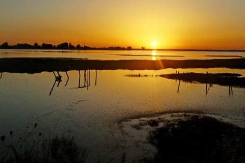 Hermosa puesta de sol sobre el agua en Flower Camping Le Pré des Sables en Pays de la Loire, Francia.