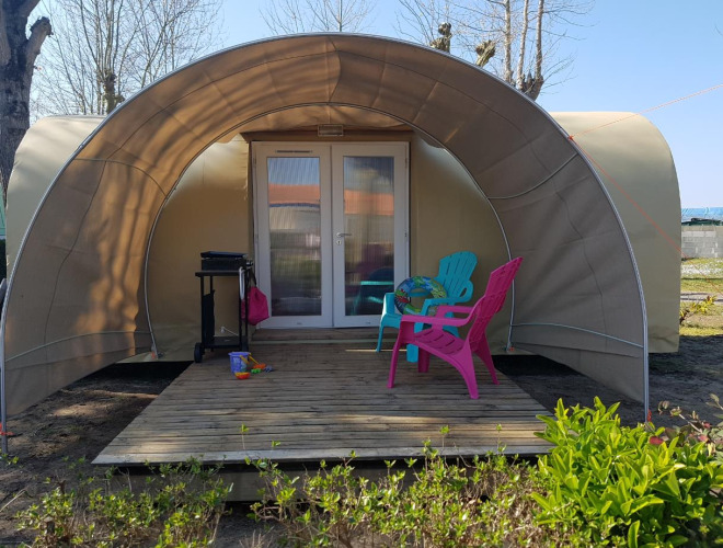 Coco Sweet safaritent bij Flower Camping Le Pré des Sables in Frankrijk, met kleurrijke stoelen op de veranda.