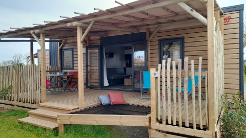 Moderne Stacaravan Premium mobilhome med stor træterrasse, afslapningsområde og udendørs spiseplads.
