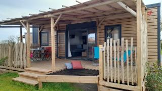 Stacaravan Premium Mobilheim mit Holzveranda, Sitzbereich und moderner Ausstattung für komfortables Camping.