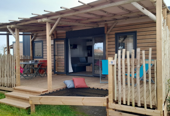 Moderne Stacaravan Premium mobilhome med stor træterrasse, afslapningsområde og udendørs spiseplads.
