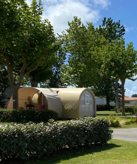 Safari-tent Coco Sweet bij Flower Camping Le Pré des Sables in Frankrijk, omgeven door bomen en groen.