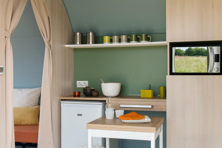 Pequeña cocina dentro de una tienda Coco Sweet en Flower Camping Le Pré des Sables, Francia.