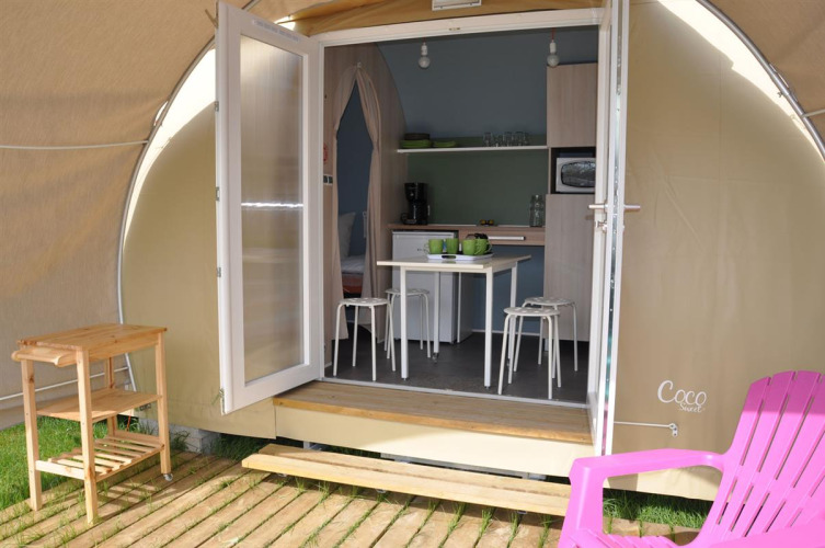 Interieur van een Coco Sweet safaritent bij Flower Camping Le Pré des Sables in Frankrijk, met eethoek.