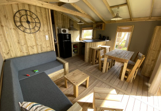 Interieur van Cabane lodge Sweet Flower Premium met houten meubelen bij Flower Camping Le Pré des Sables.