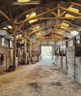Binnenkant van een rustieke paardenstal bij Feather Down Ecuries de Gapennes, vakantiepark in Hauts-de-France, Frankrijk.