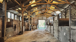 Binnenkant van een rustieke paardenstal bij Feather Down Ecuries de Gapennes, vakantiepark in Hauts-de-France, Frankrijk.