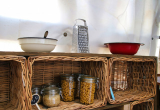 Étagère de cuisine en osier avec bols, râpe et bocaux à Feather Down Ecuries de Gapennes, en France.