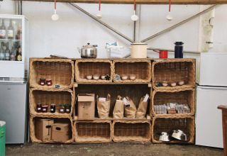 Cestas con productos locales y tarros en estantes dentro de la tienda de Feather Down Ecuries de Gapennes.