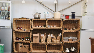 Mandjes met lokale producten en potjes op schappen bij Feather Down Ecuries de Gapennes boerderijwinkel.