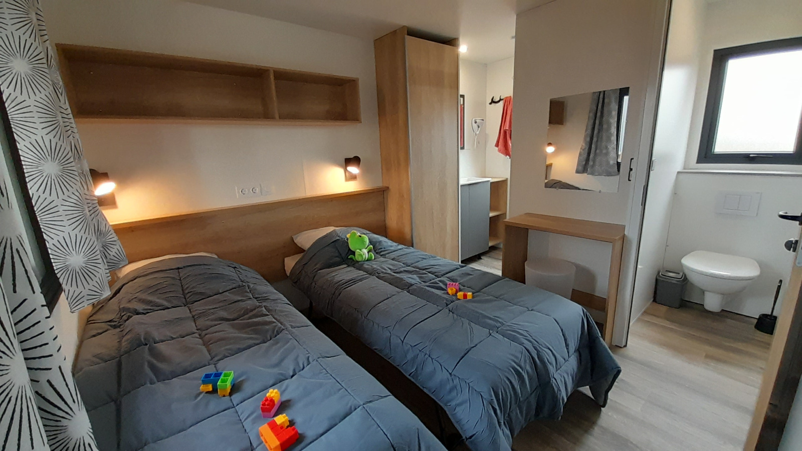 Moderne stacaravan slaapkamer bij Stacaravan Premium, Flower Camping Le Pré des Sables, met twee eenpersoonsbedden.