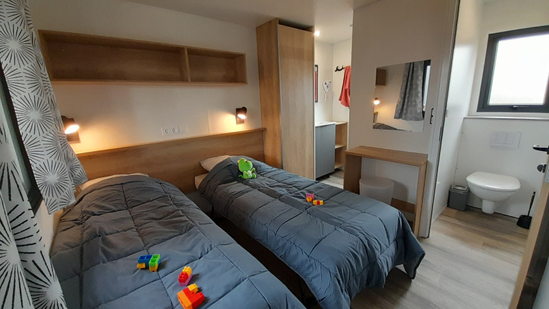 Et moderne mobilhomeværelse på Stacaravan Premium, Flower Camping Le Pré des Sables, med to enkeltsenge.