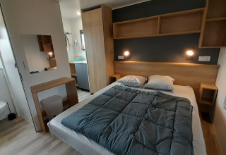 Slaapkamer in een Stacaravan Premium bij Flower Camping Le Pré des Sables in Frankrijk met moderne inrichting.