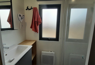 Badkamer in een Stacaravan Premium bij Flower Camping Le Pré des Sables met raam en douchecabine.