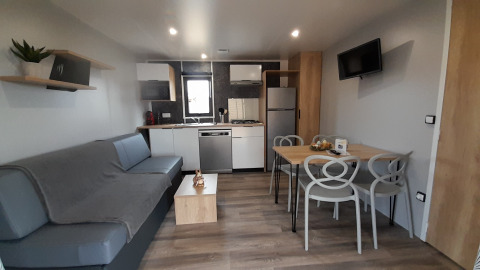 Moderne stue og køkken i en Stacaravan Premium på Flower Camping Le Pré des Sables, Frankrig.