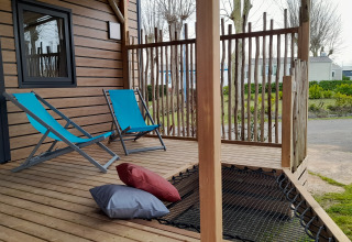 Houten veranda bij de Stacaravan Premium op Flower Camping Le Pré des Sables met blauwe stoelen.