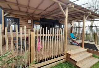 Houten terras met stoel bij Stacaravan Premium op Flower Camping Le Pré des Sables in Frankrijk.