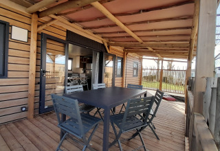 Udendørs terrasse af Stacaravan Premium på Flower Camping Le Pré des Sables, træbord og stole.