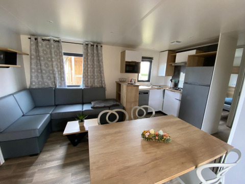 Interiør af Stacaravan Premium på Flower Camping Le Pré des Sables i Frankrig med moderne møbler.