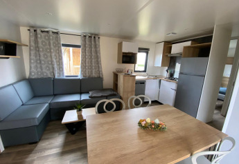 Interiør af Stacaravan Premium på Flower Camping Le Pré des Sables i Frankrig med moderne møbler.