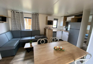 Interior of Stacaravan Premium mobile home at Flower Camping Le Pré des Sables, France, with modern decor.