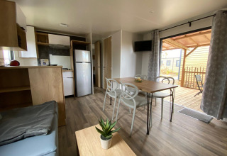 Interior of Stacaravan Premium at Flower Camping Le Pré des Sables, featuring kitchen, dining area and terrace.