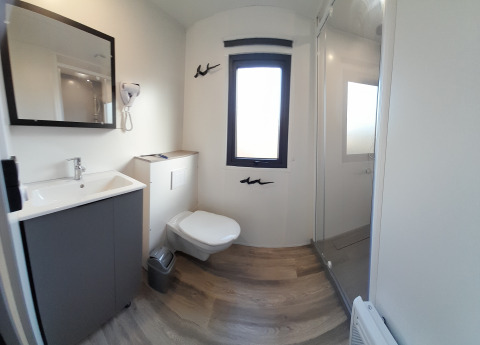 Moderne badeværelse i Stacaravan Premium på Flower Camping Le Pré des Sables med toilet, bruser og vask.