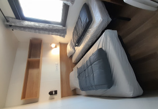 Room with two single beds, window, shelf and wooden floor at Stacaravan Premium, Flower Camping Le Pré des Sables.