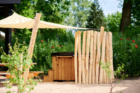 Bañera de hidromasaje entre vegetación en flor - Vakantiepark de IJsvogel - Voorthuizen, Gelderland, Países Bajos