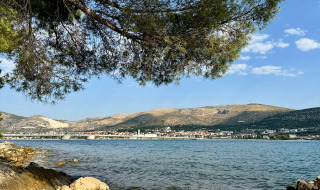 Rotsachtige kust met dennen en uitzicht over het water richting het stadje Vrsar in Istrië, Kroatië.