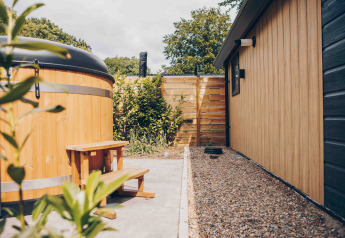 Außenbereich des Tiny Loft mit Whirlpool und Holzverkleidung im Veluwepark de Bosgraaf, Niederlande.