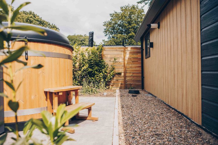 Área exterior de Tiny Loft con jacuzzi y revestimiento de madera en Veluwepark de Bosgraaf, Países Bajos.