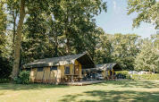 Tenda safari al Recreation Park Den Blanken nei Paesi Bassi circondata da alberi e prato verde.