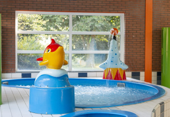 Piscine intérieure pour enfants avec structures ludiques colorées, dont un poisson jaune, à Safarilodge Impala, IJsselhof.