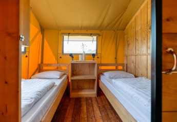 Interior view of Safarilodge Gazelle safari tent with two single beds at Vakantiepark IJsselhof, Netherlands.